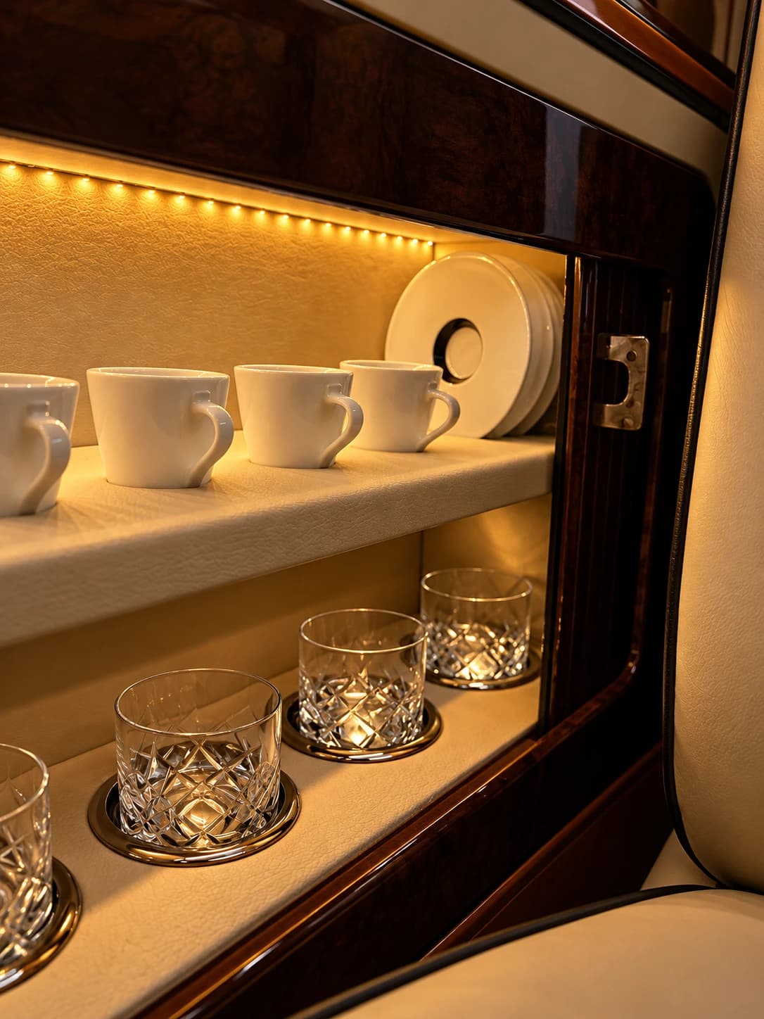 Porcelain cups and crystal glasses in the Jet Van VIP's lit cabinet